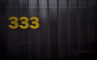 a black and yellow sign with the number 333 on it