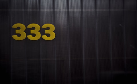 a black and yellow sign with the number 333 on it