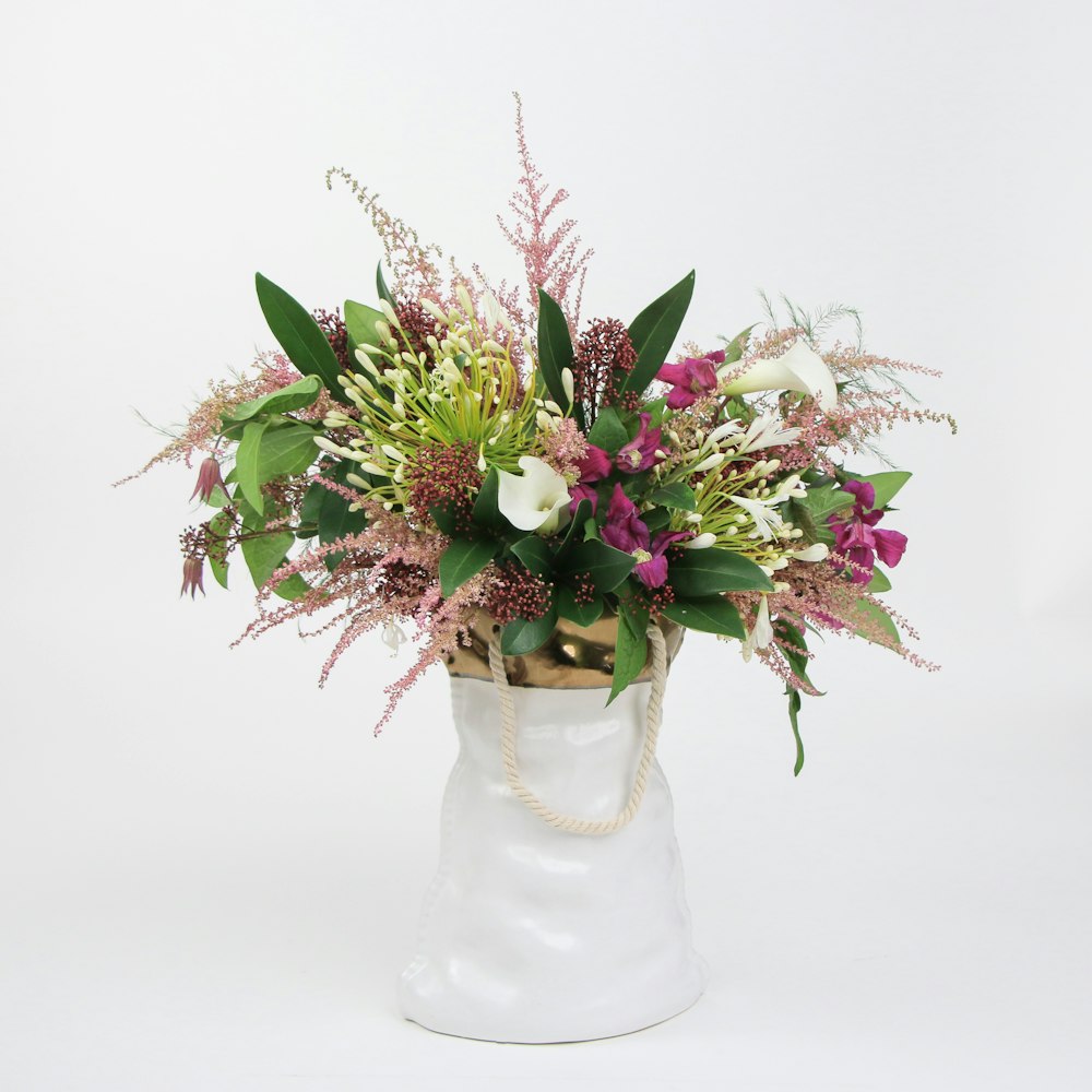 a bouquet of flowers in a white vase