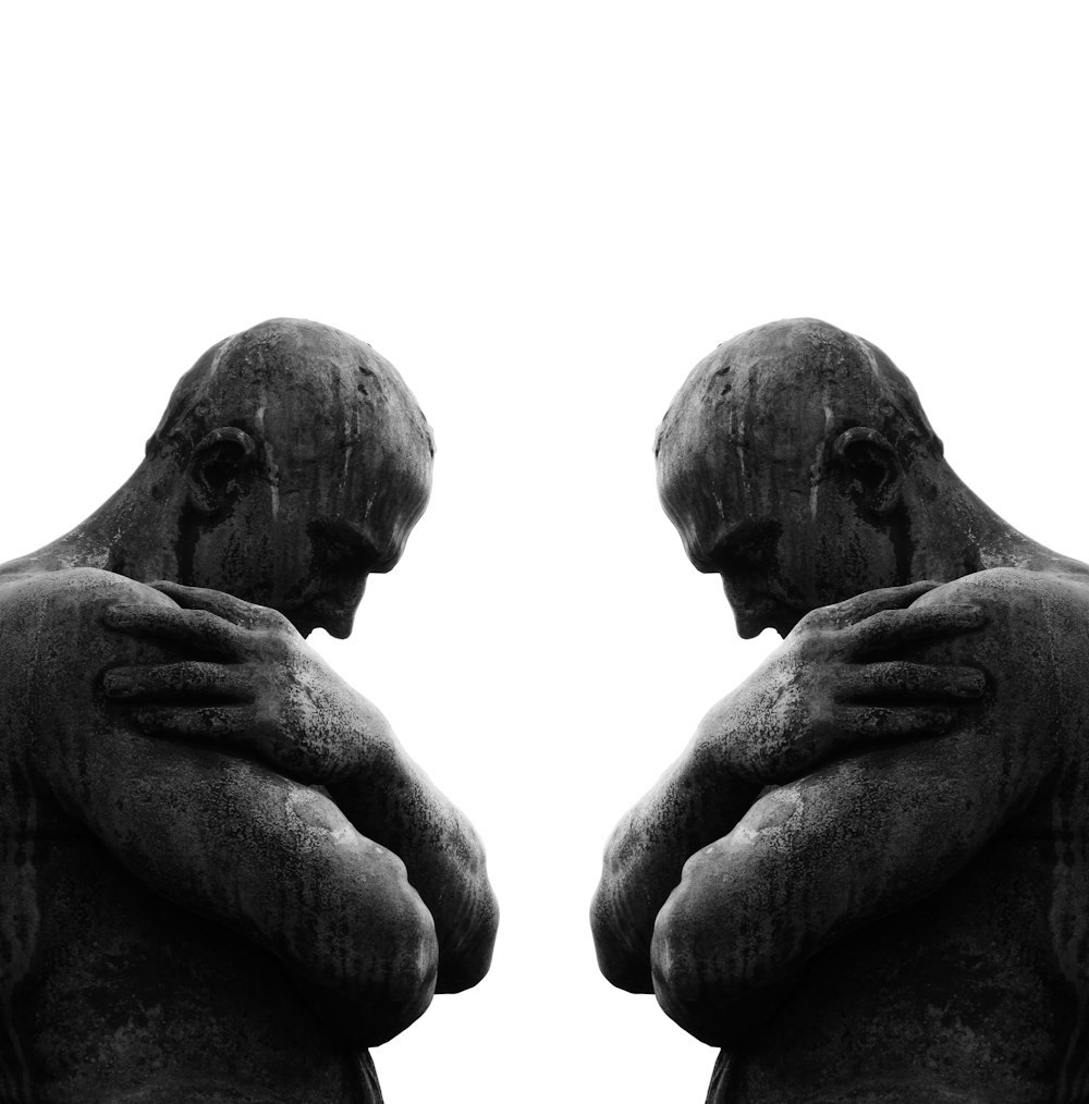 a statue of a man holding his hands to his chest