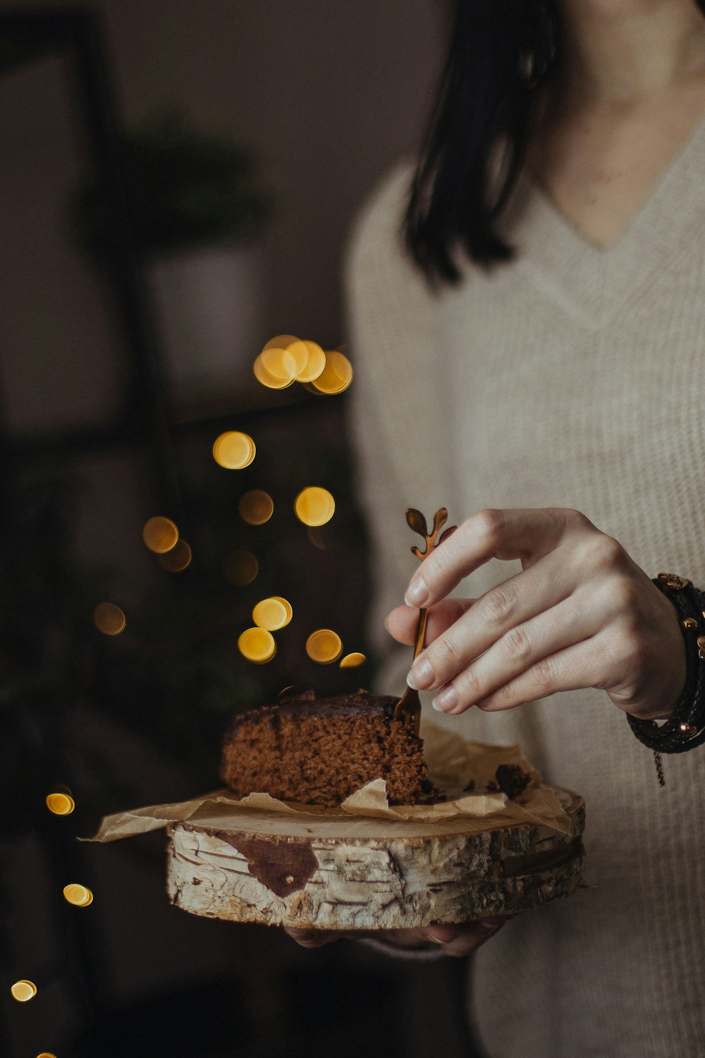 a person holding a piece of cake on a table