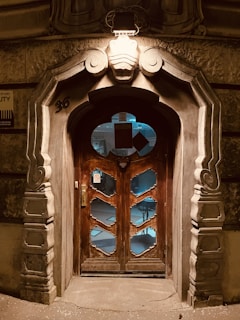 a large wooden door with a clock on it's side