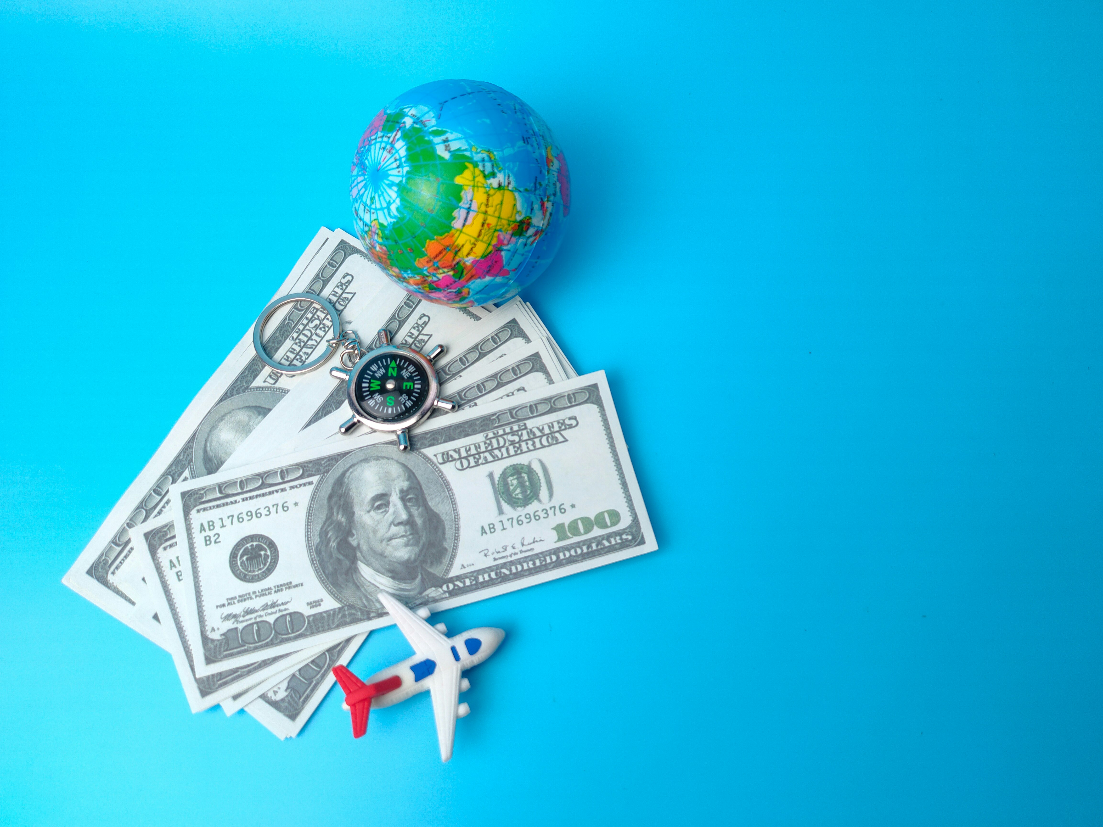 banknotes, earth globe and airplane on blue background.