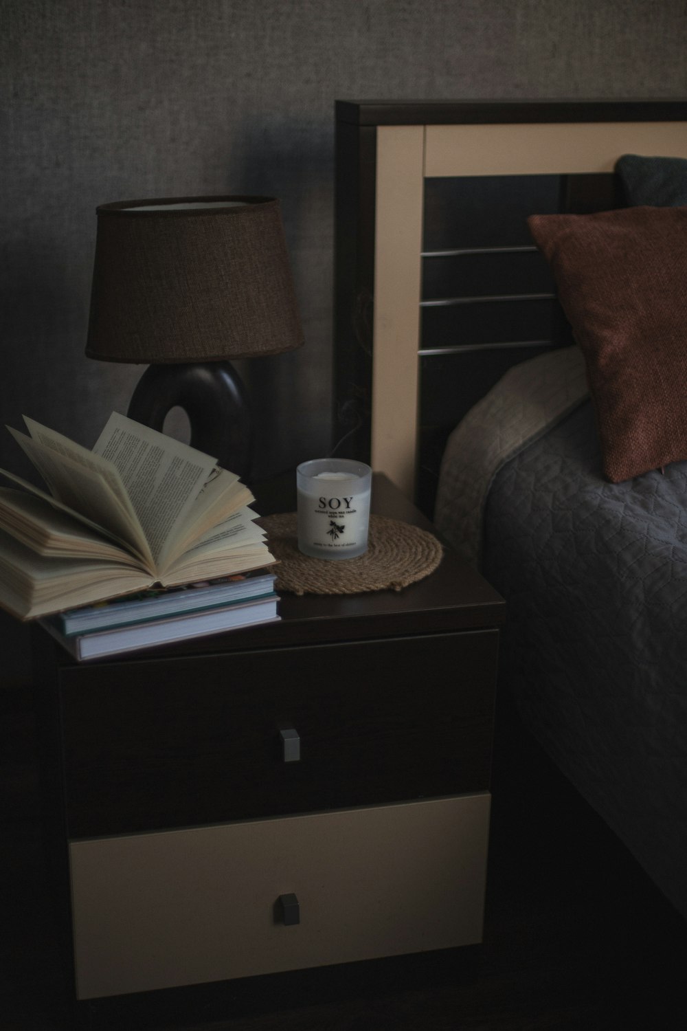 una mesita de noche con un libro y una taza de café