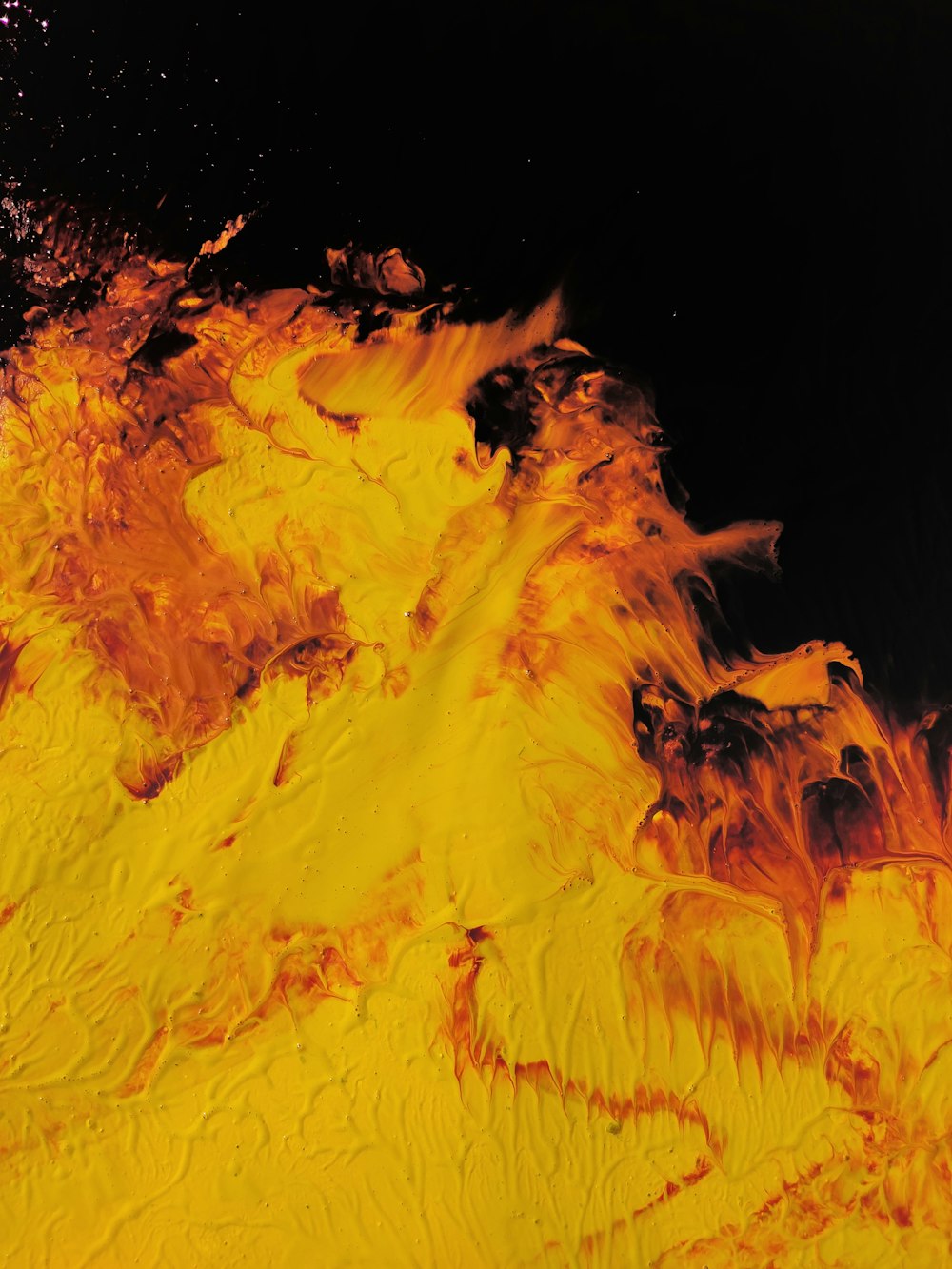 a close up of a yellow substance on a black background