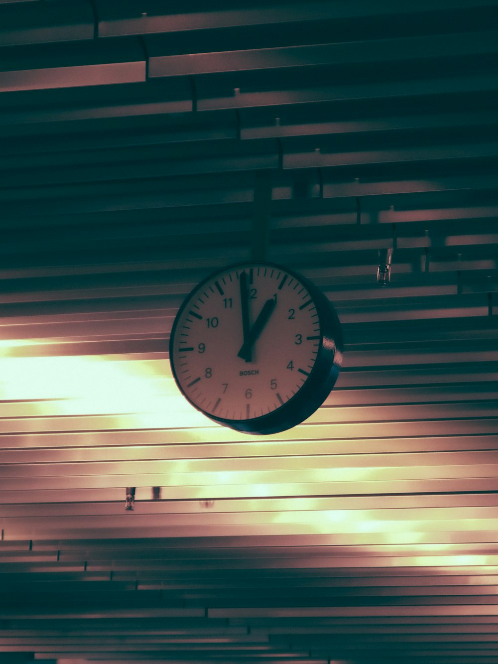 a clock hanging from the ceiling of a building