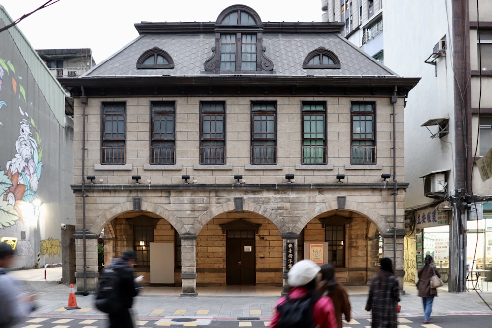 a group of people walking down a street next to a building