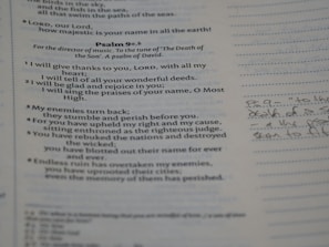 A close-up view of a Bible page showing text from Psalm 9a, with some handwritten notes on the side. The text is printed in black ink and the notes are written in cursive with a pen. The page layout includes structured lines and numbers for reference.