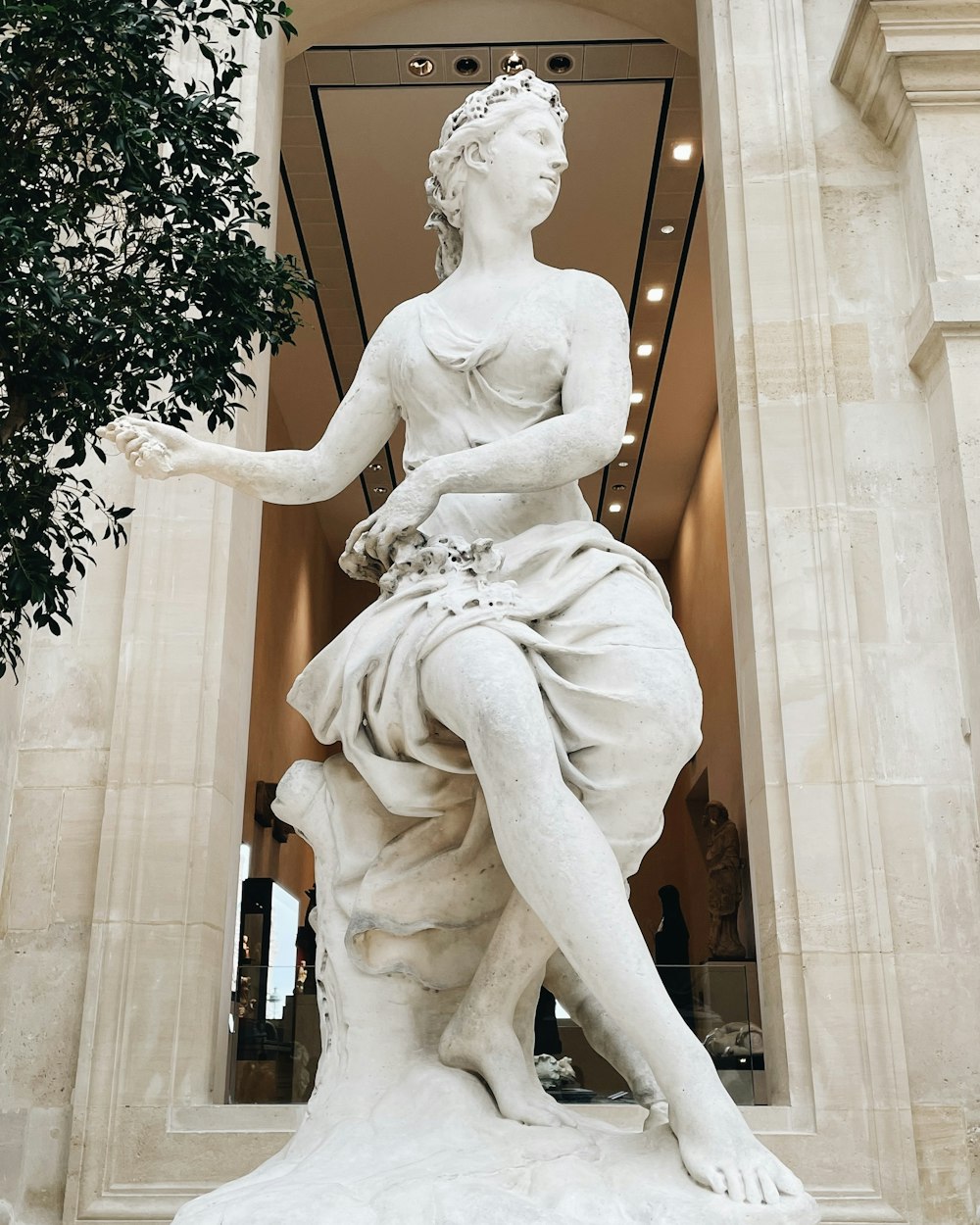 a statue of a woman sitting on a rock