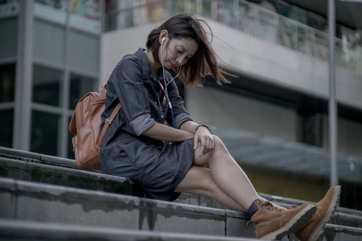 Woman sitting on a ledge using her phone