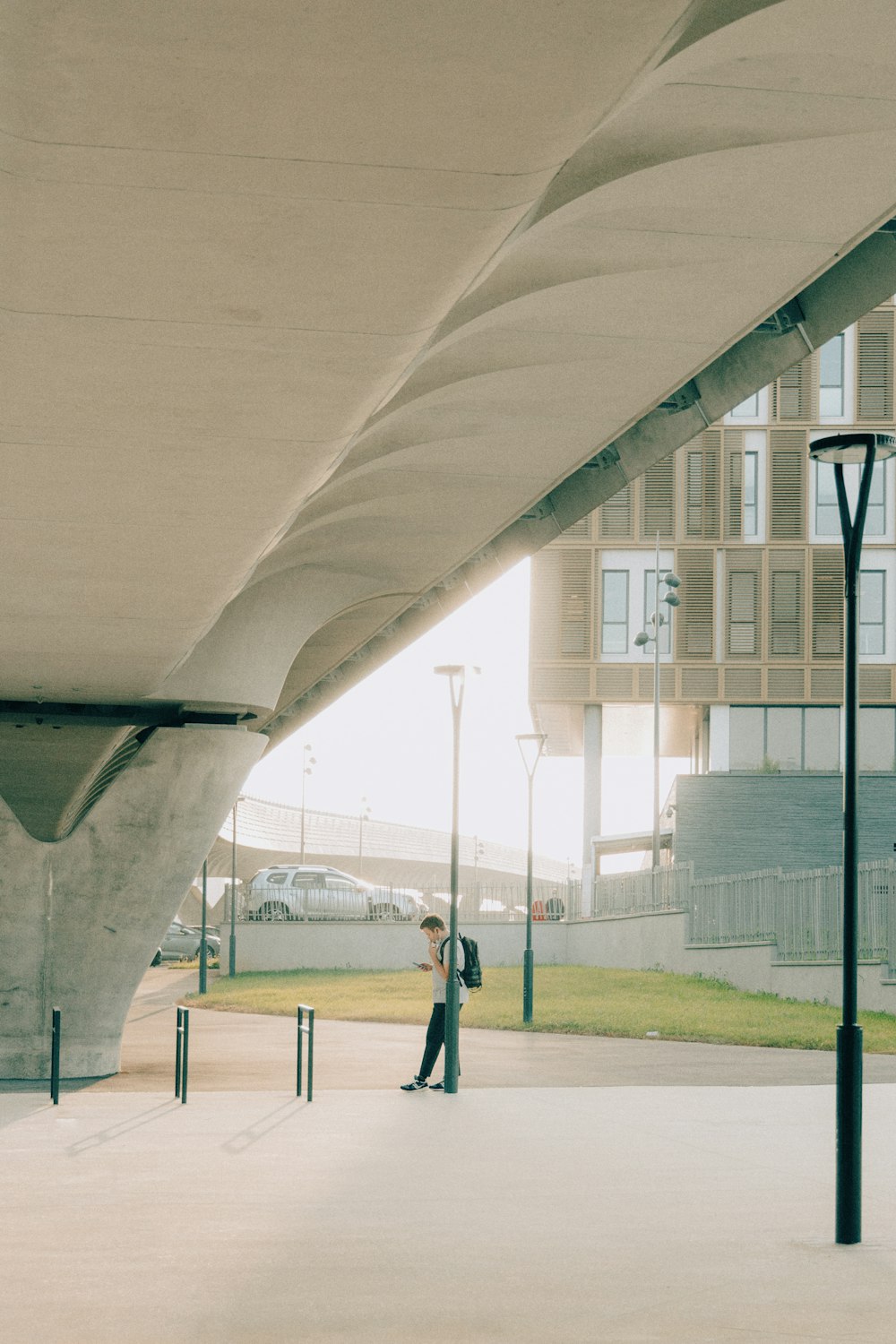 a man standing under a bridge next to a street light