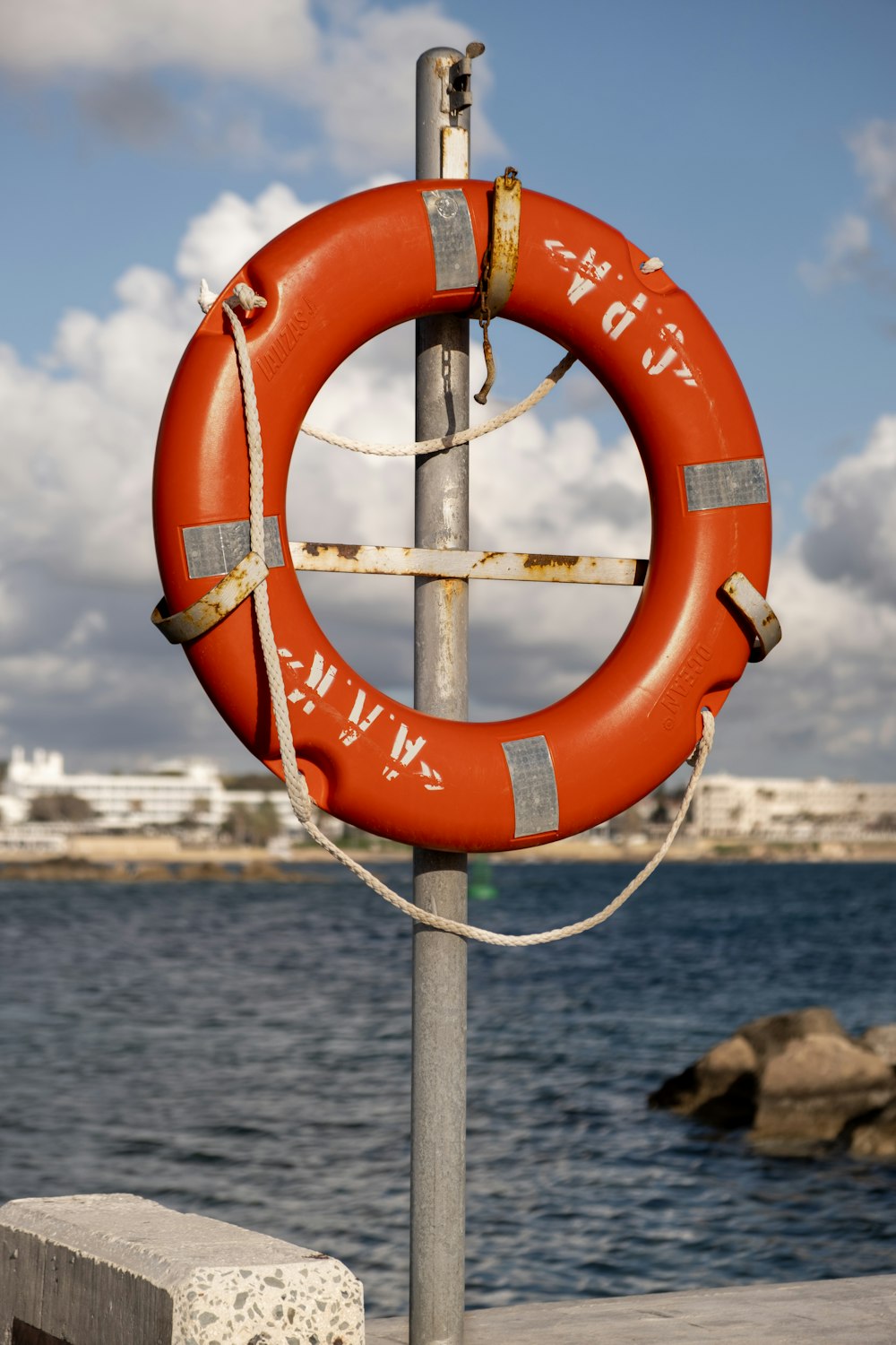 a life preserver on a pole near a body of water