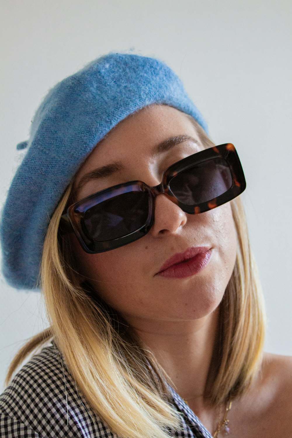 a woman wearing a blue hat and sunglasses