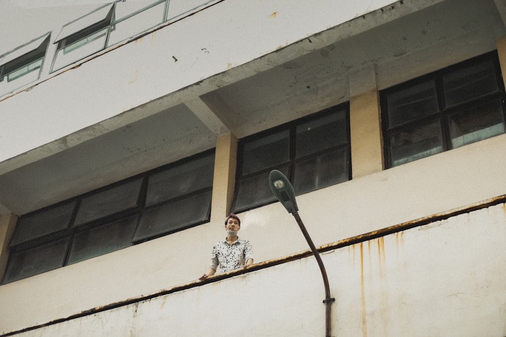 a man standing on a ledge next to a street light