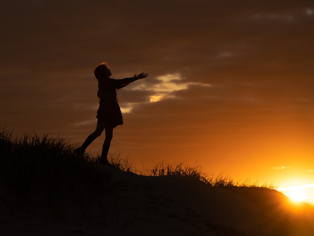 a person standing on top of a grass covered hill