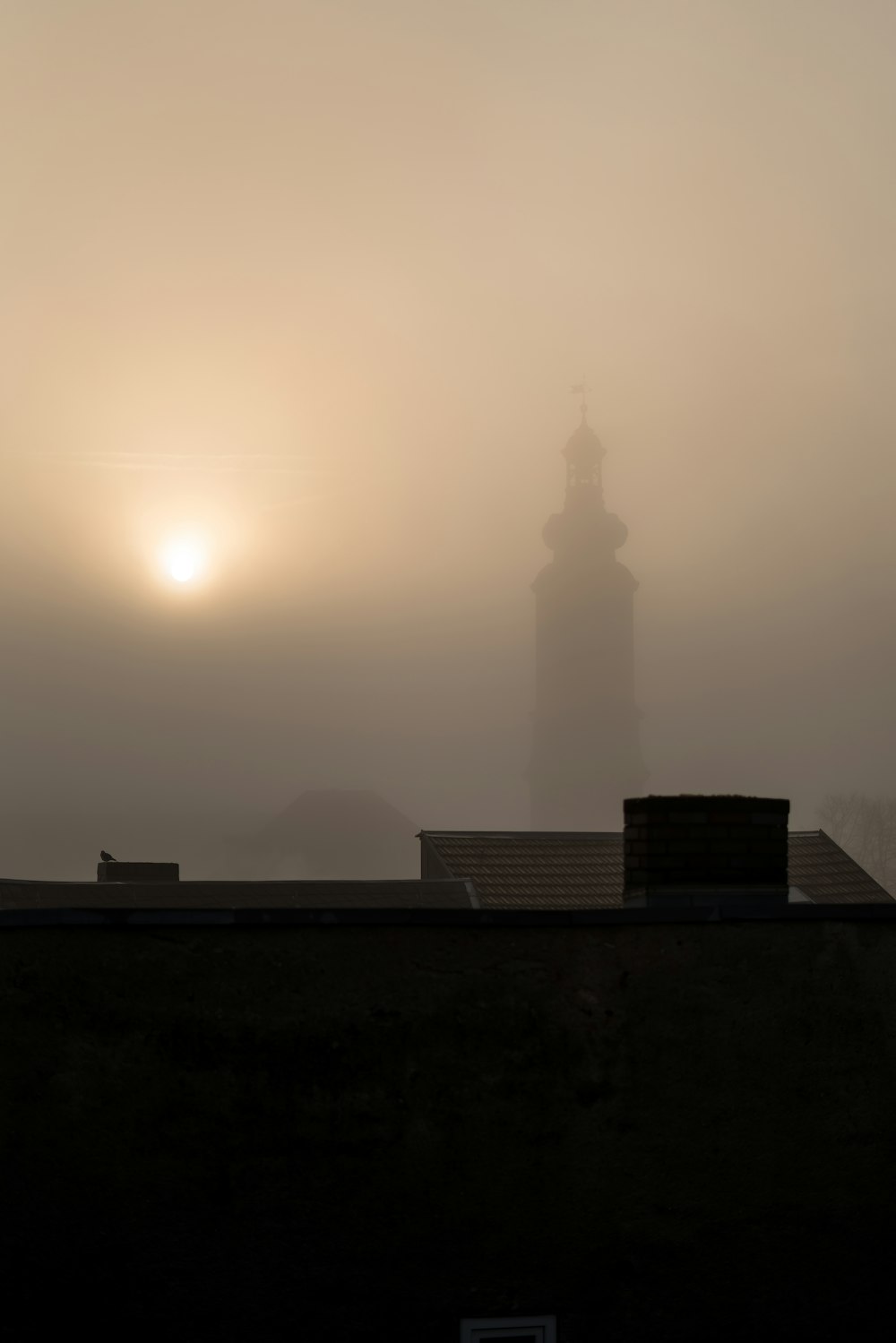 a foggy sky with a light tower in the distance