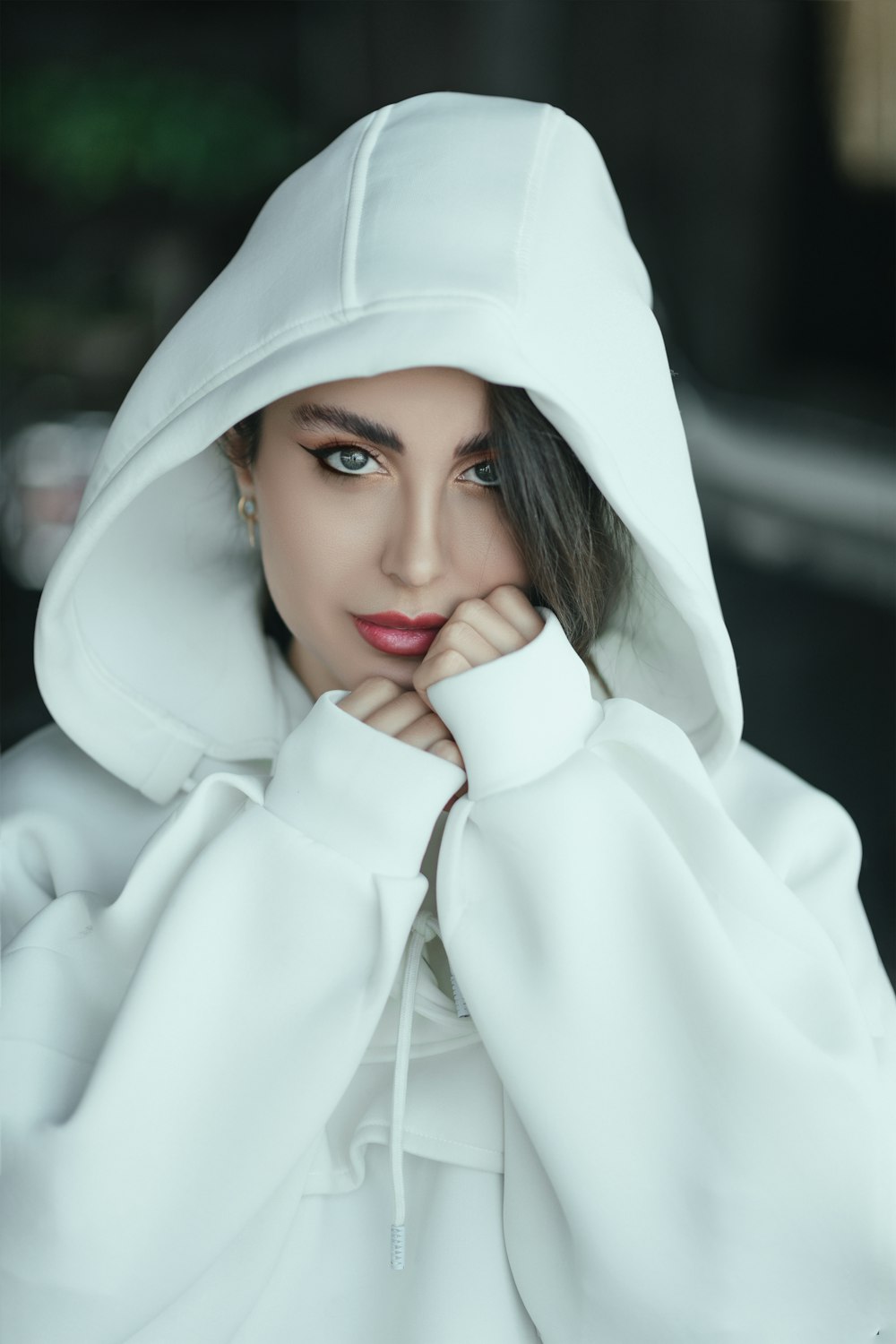 a woman in a white hoodie is posing for a picture