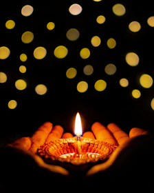 Soft candlelight illuminating a circle of women holding hands in a cozy room.