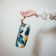 A happy customer holding a colorful mofleema pouch.