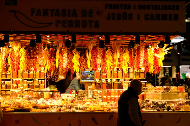A vibrant market stall displaying fresh garlic bulbs, peppercorns, and cardamom pods in rustic baskets.