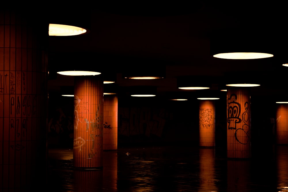 uma sala mal iluminada com luzes redondas e grafite nas paredes