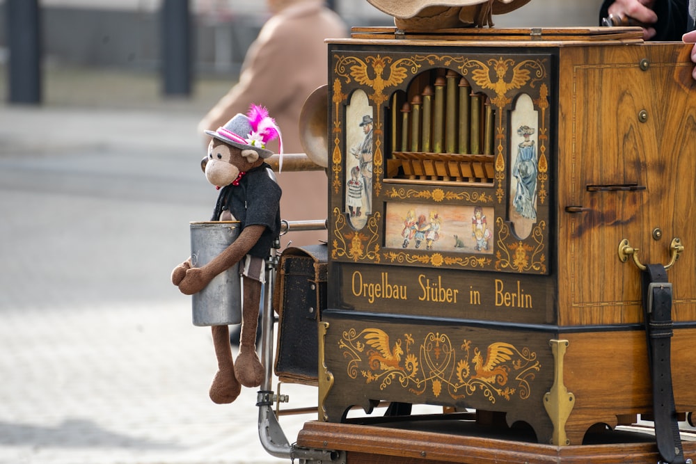 a teddy bear sitting on top of an old fashioned organ