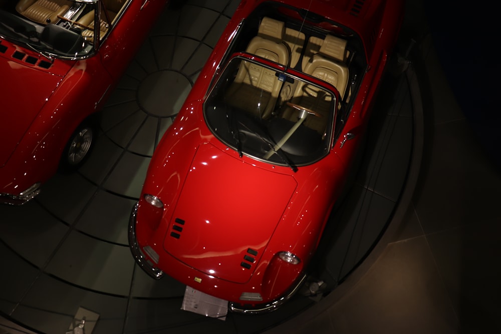 two red sports cars parked in a showroom