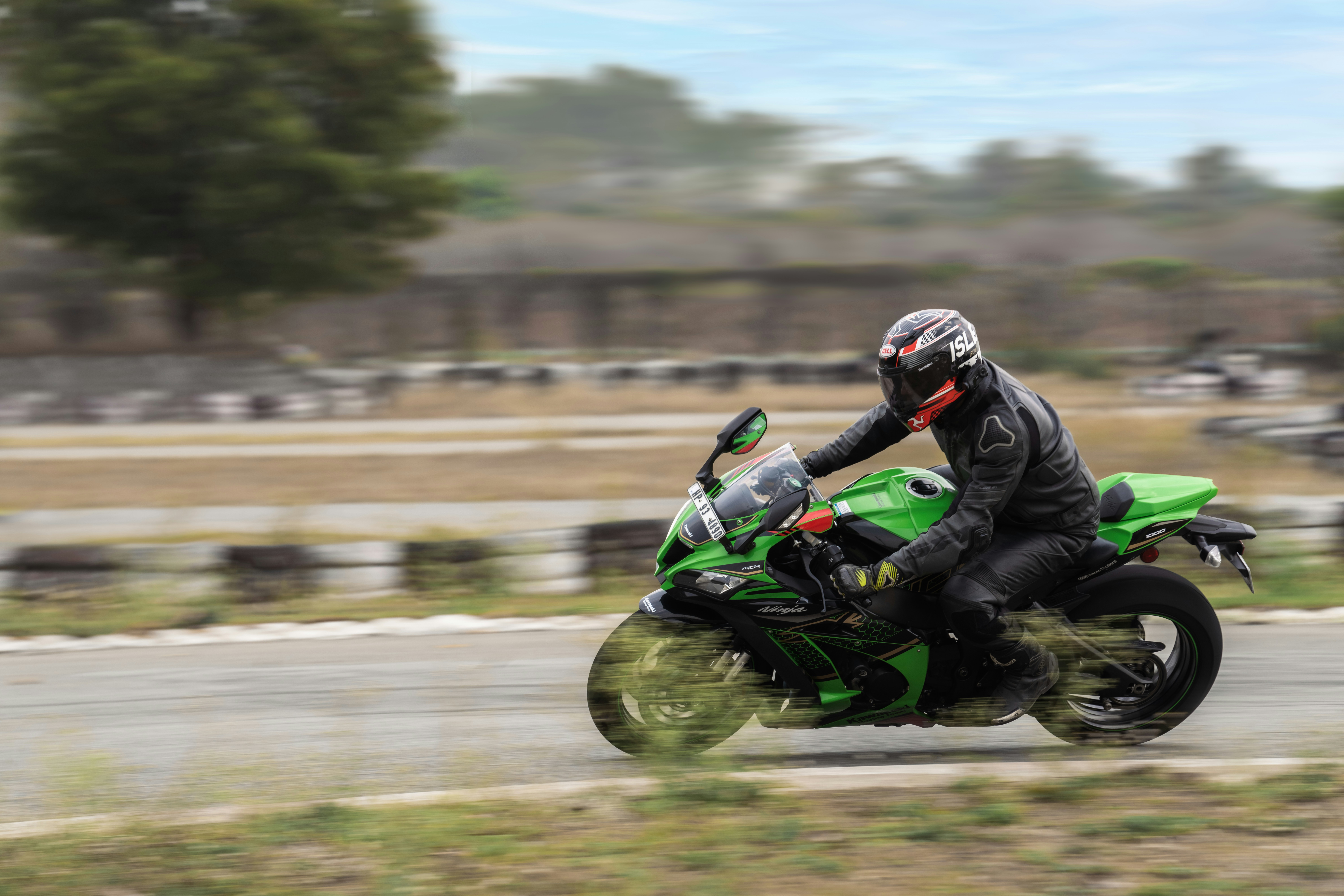 Kawasaki Ninja 400 verde en pista de carreras con postura agresiva