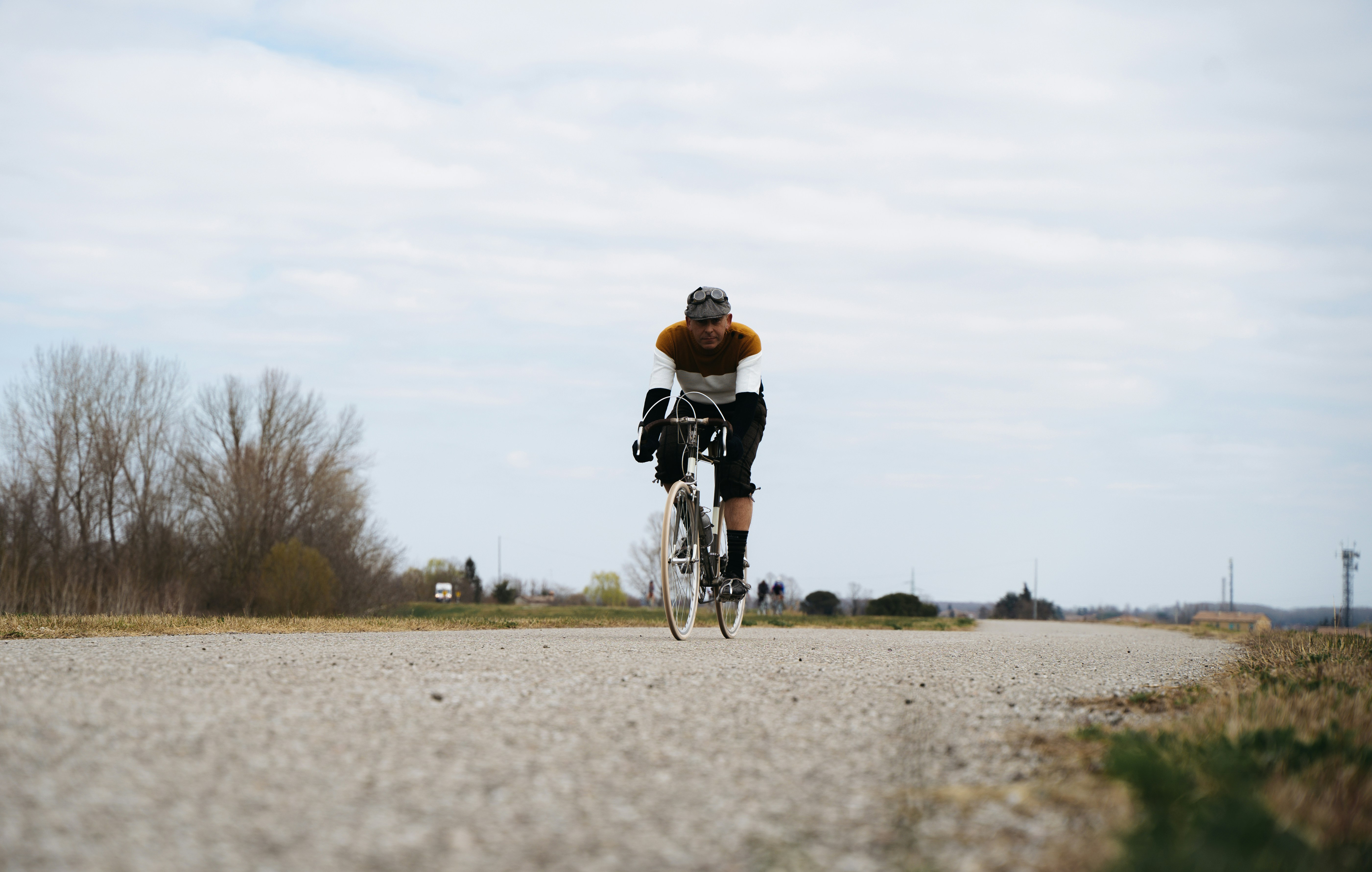 a man riding a bike down a gravel road