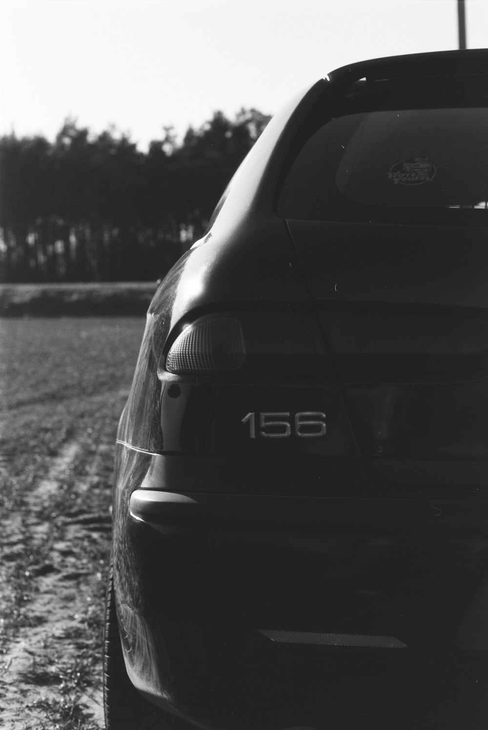 a black and white photo of a car parked in a field