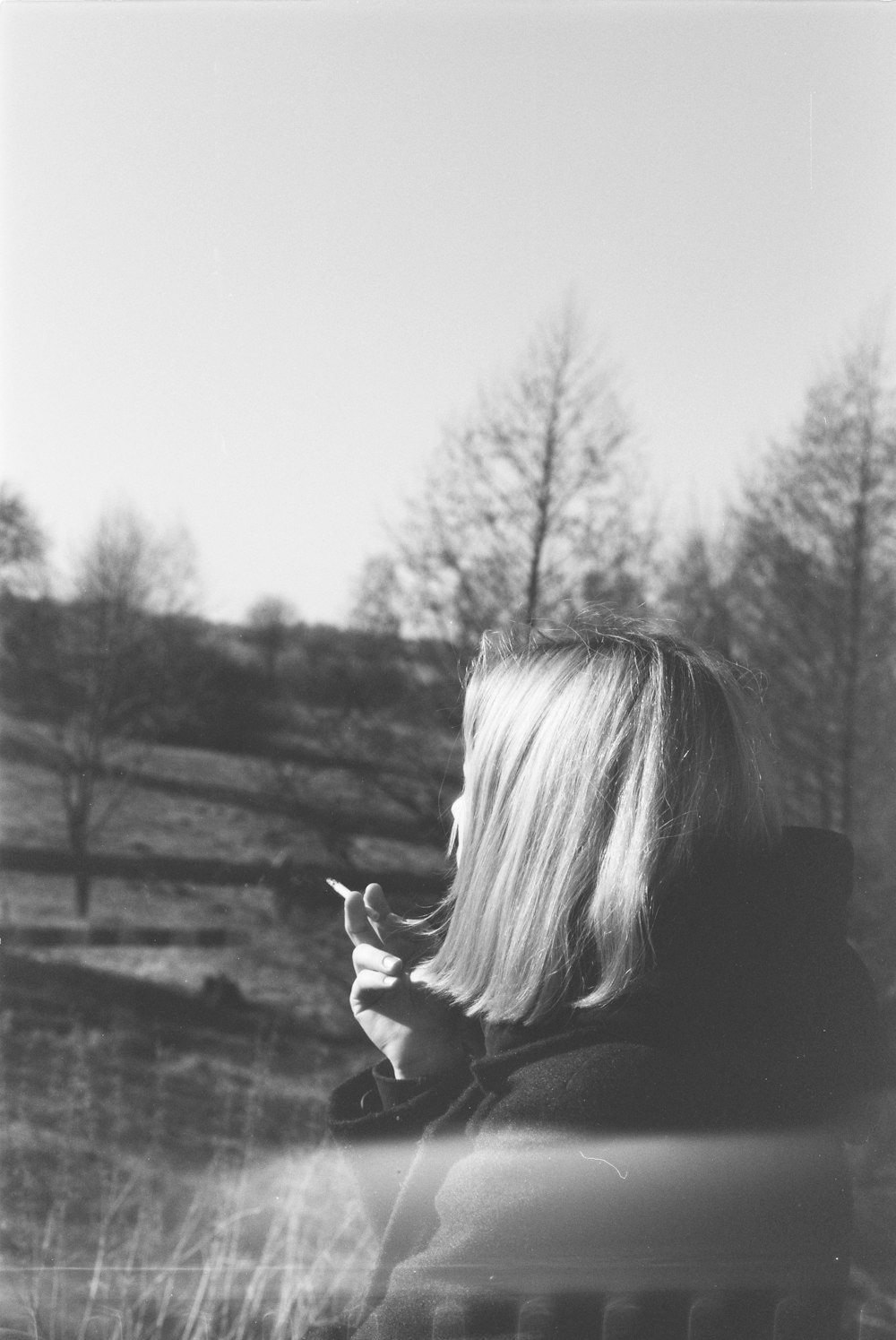 a black and white photo of a woman smoking a cigarette
