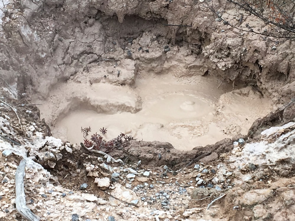 un trou dans le sol qui est rempli de boue
