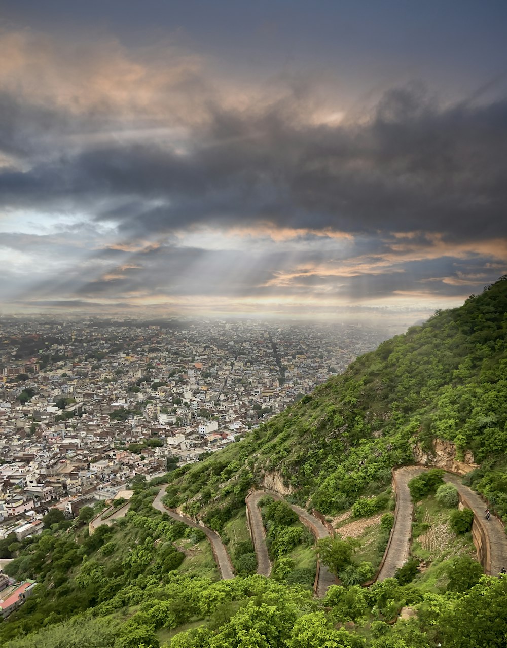 a scenic view of a city and a winding road