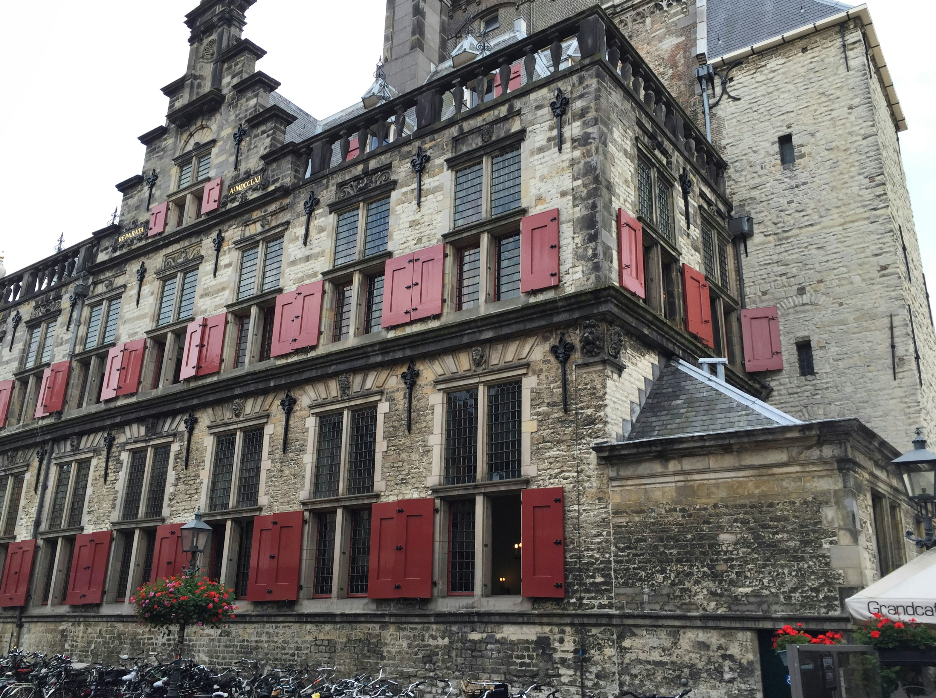 a tall building with red shutters and a clock tower