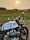 Man riding a Royal Enfield Classic 350 along the coastline near Jagannath Temple at sunset.