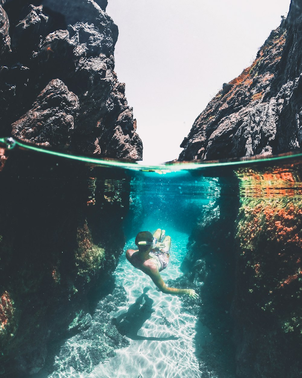 a person swimming in the water near some rocks