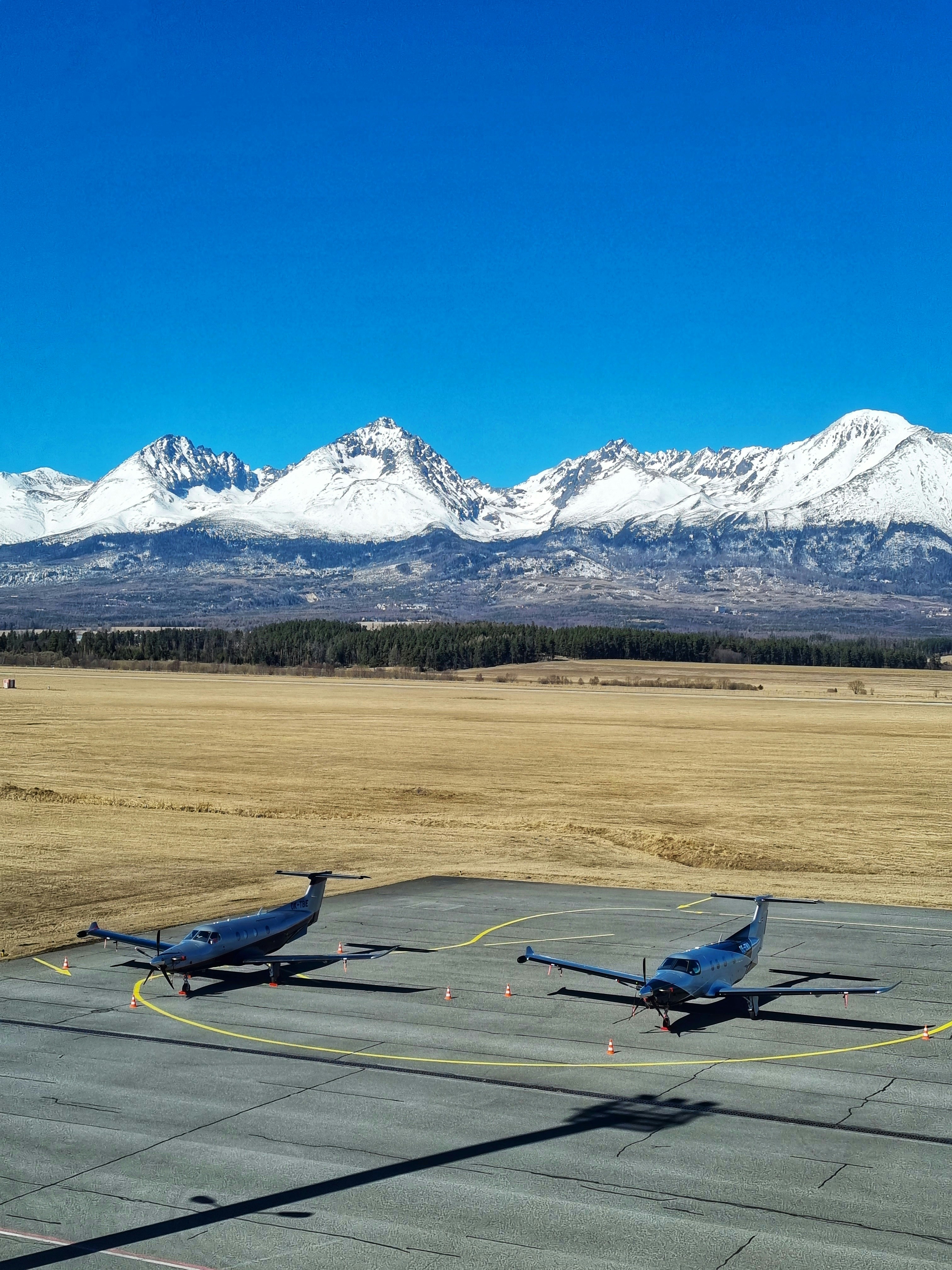 A couple of small airplanes sitting on top of an airport tarmac photo ...