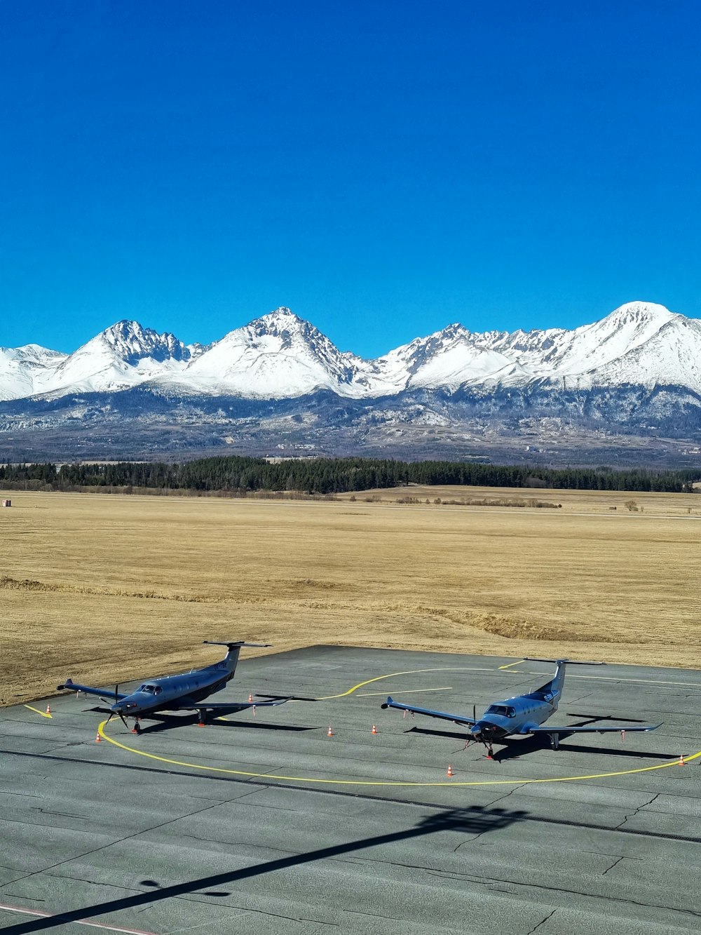 a couple of small airplanes sitting on top of an airport tarmac