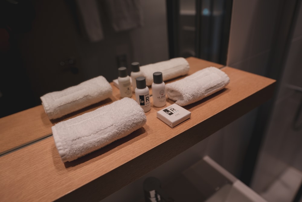 a bathroom counter with towels and bottles on it