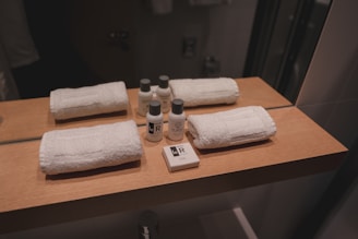 a wooden counter topped with bottles and towels