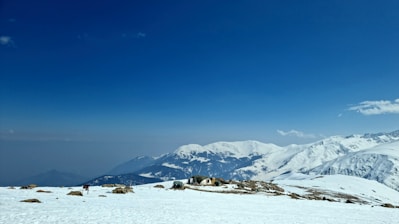 a snow covered mountain with a house on top of it