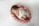 A smiling mother holding her newborn wrapped in a soft basket from nestling.