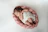 A smiling mother holding her newborn wrapped in a soft basket from nestling.