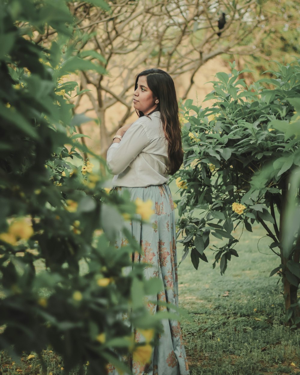 a woman standing in front of a tree