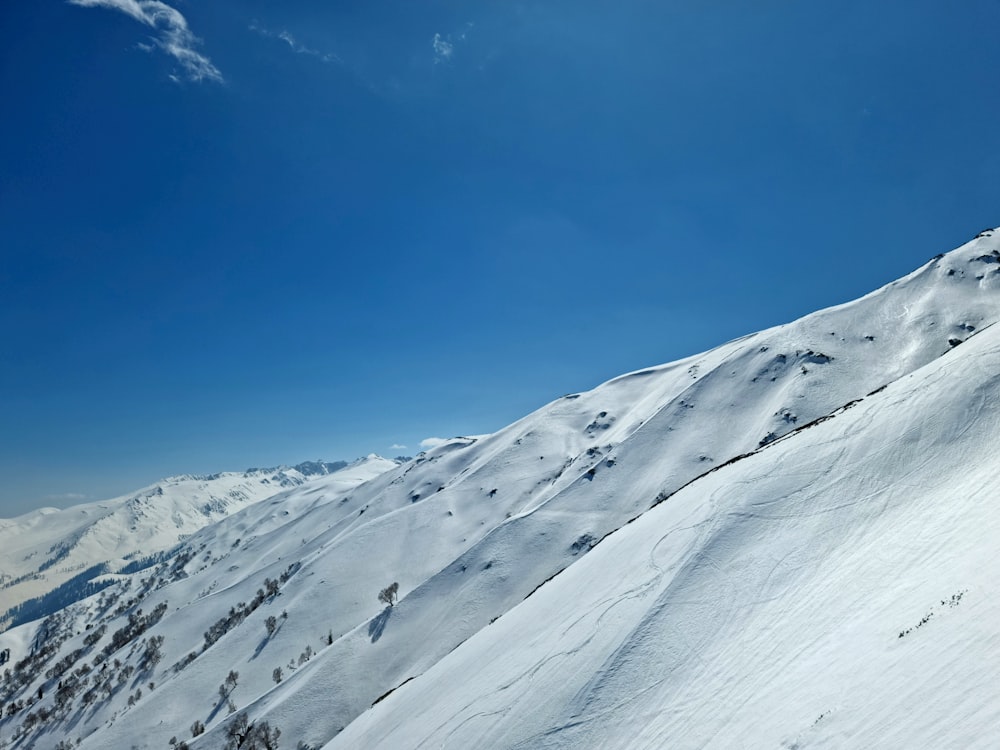 a man riding skis down the side of a snow covered slope