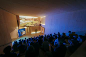 Photo of a small, cozy cinema room with audience seats and a screen showing a short film.