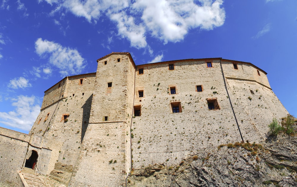 Un grande castello di pietra seduto sulla cima di una scogliera