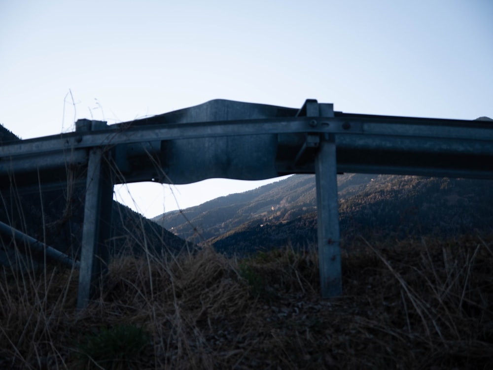 a metal fence sitting on top of a grass covered hillside