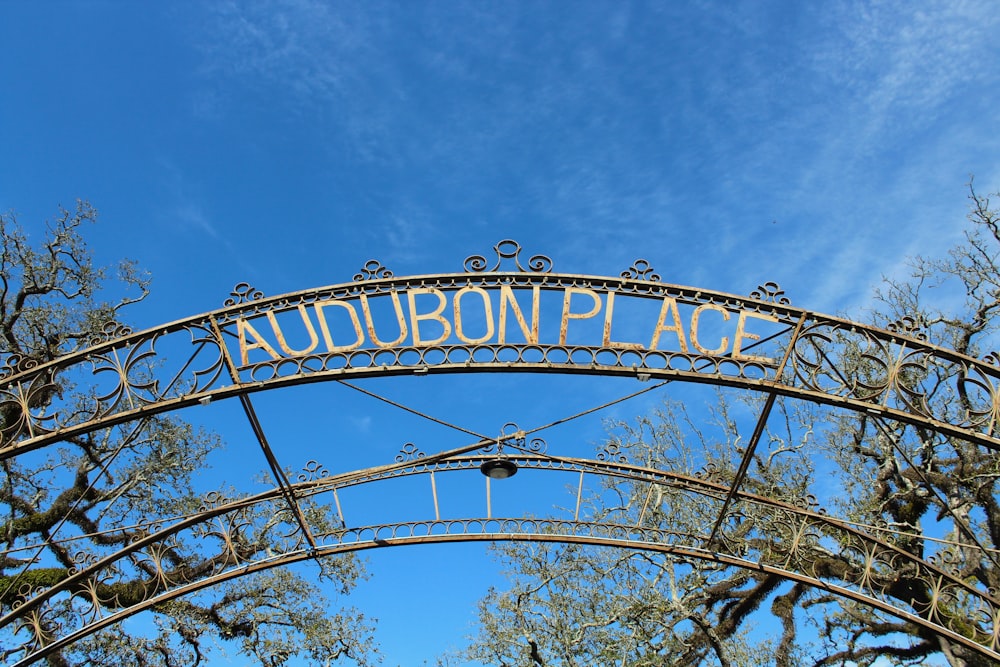 a metal arch with a sign that reads audubon place