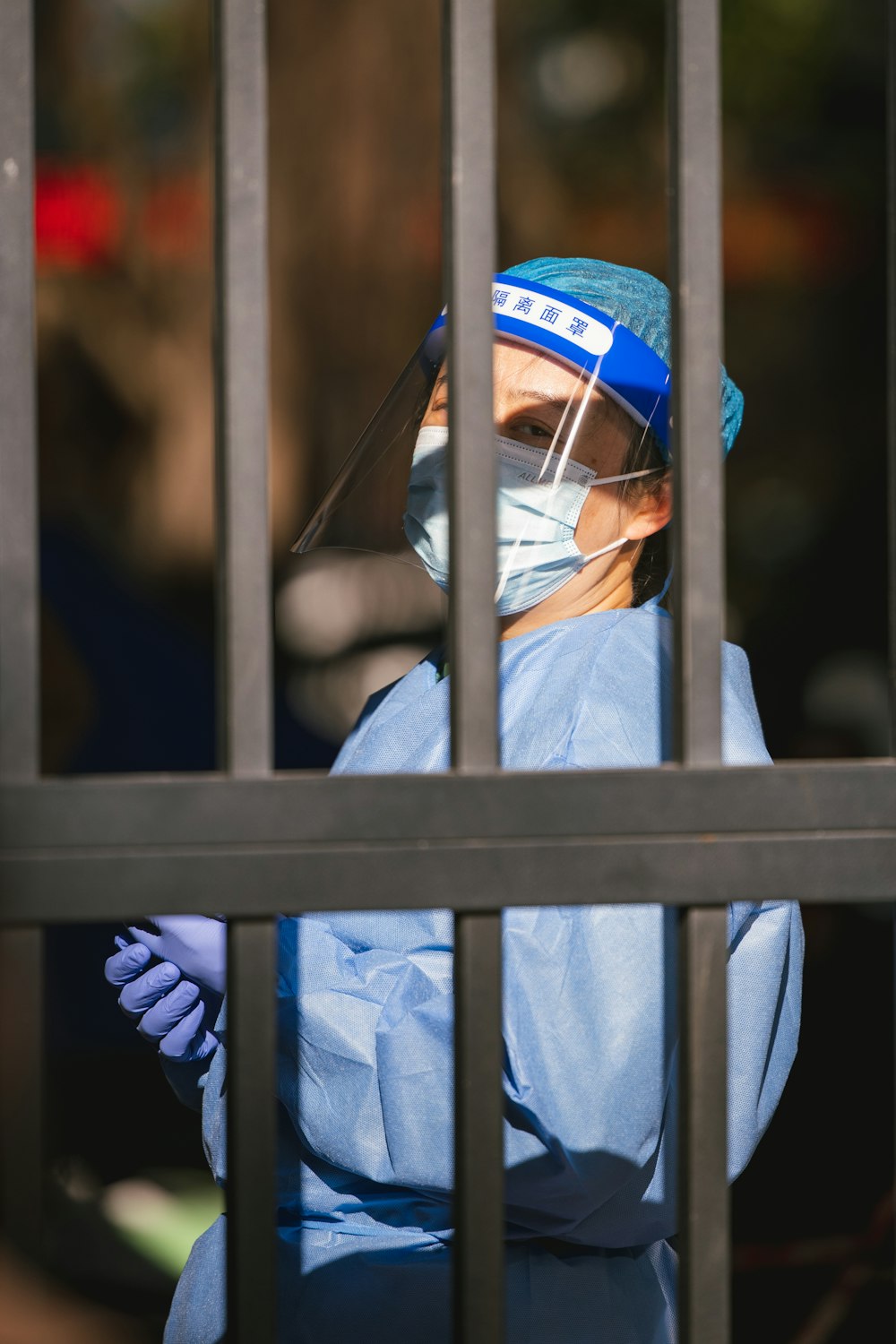 a person in a blue suit and mask behind bars